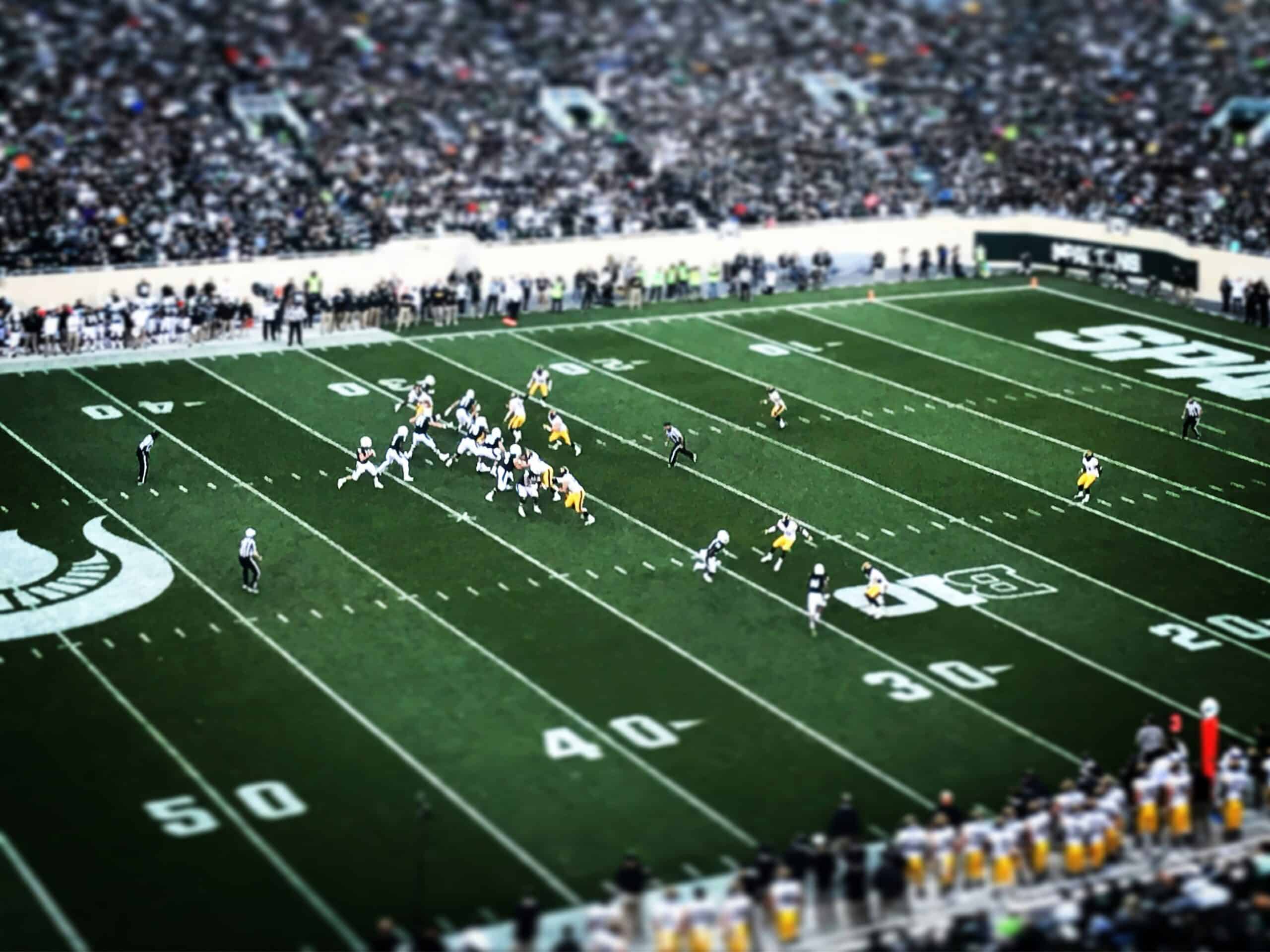 American football players competing on a football field, illustrating the importance of protective equipment
